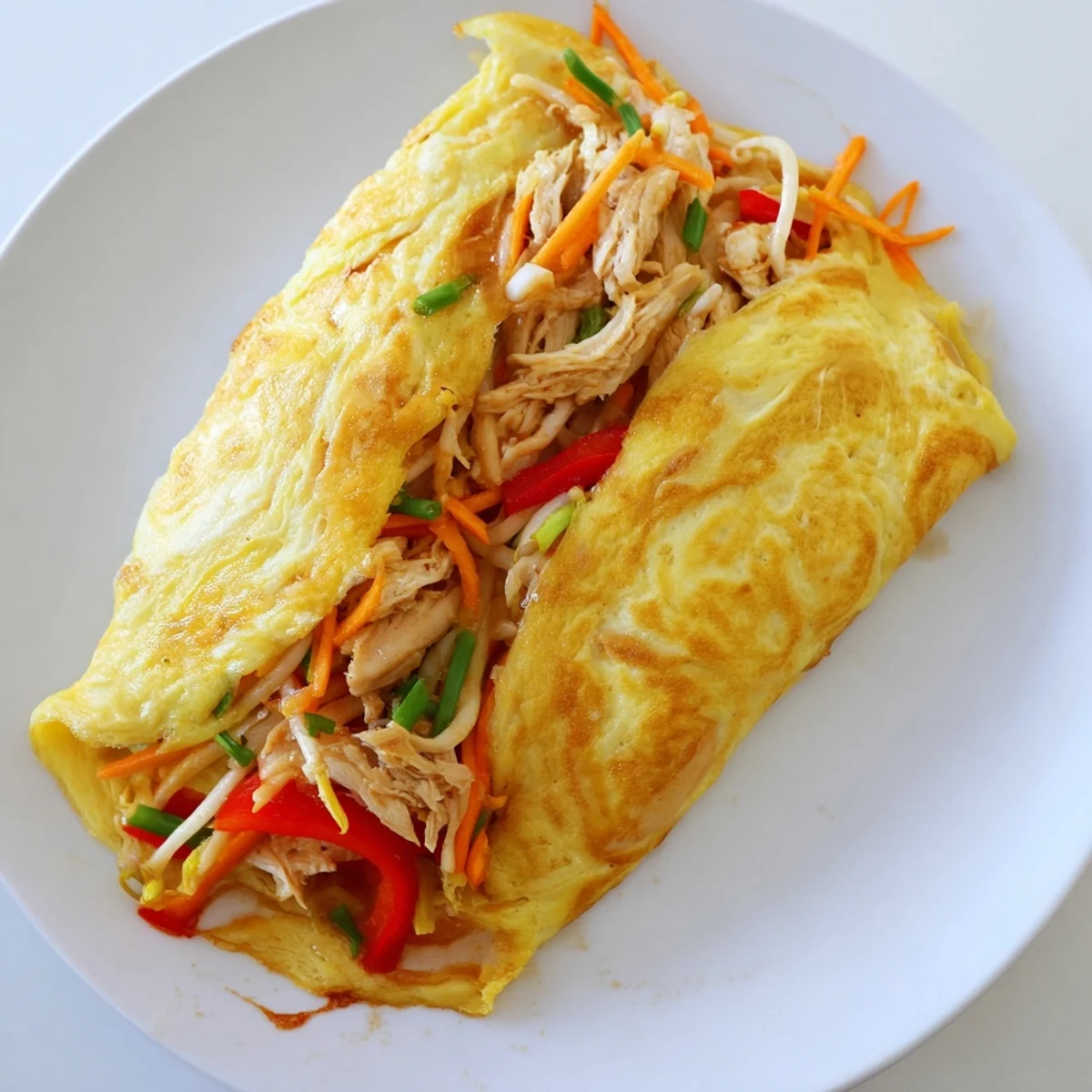 Golden Chinese omelette folded over crisp vegetables and tender shredded chicken