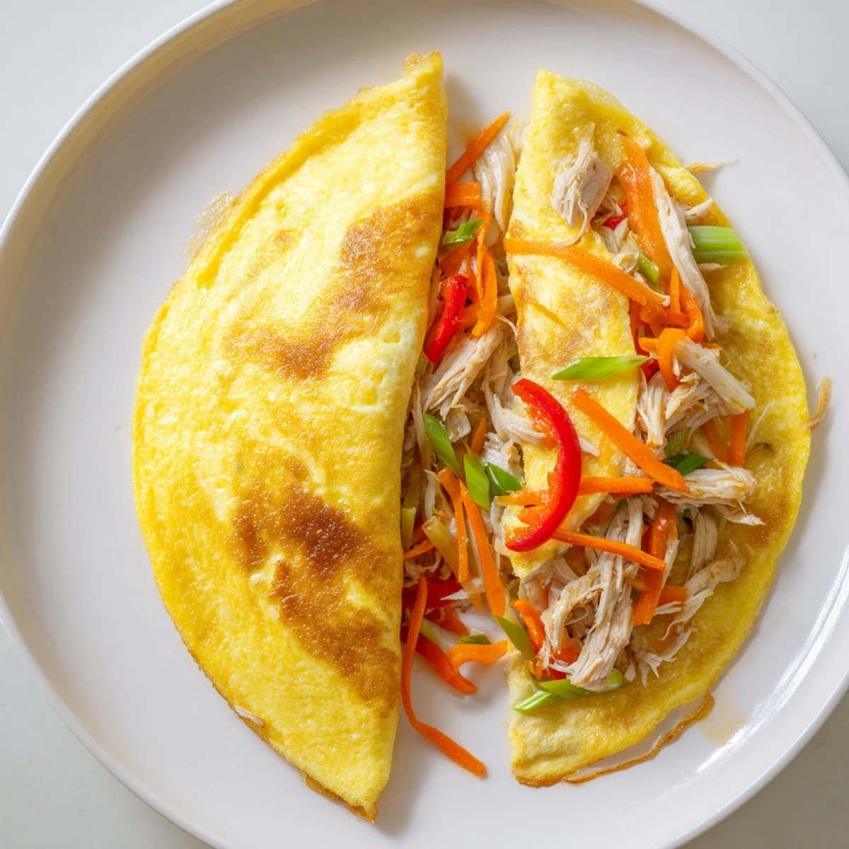 Fluffy Chinese omelette drizzled with sesame soy sauce on white plate