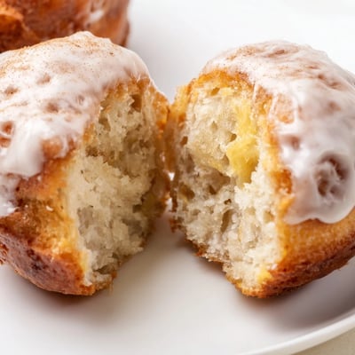 Baked Banana Donuts sliced open showing moist, fluffy, banana-speckled crumb