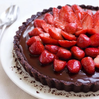 A slice of Dark Chocolate Strawberry Tart Recipe on plate, flaky crust visible