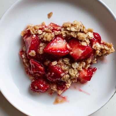 Warm Fresh Strawberry Crisp Recipe with buttery oat topping, juicy strawberries visible