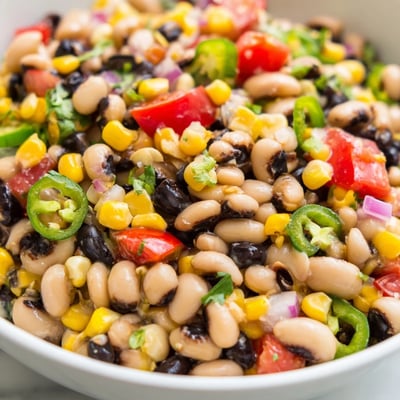 Bright Cowboy Caviar scooped up with crispy tortilla chips at a summer gathering